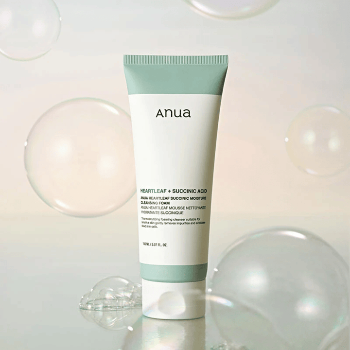 Produktbillede af Anua Heartleaf + Succinic Acid Moisture Cleansing Foam omgivet af transparente bobler. Billedet forstærker følelsen af mild rengøring, friskhed og et luftigt skum.