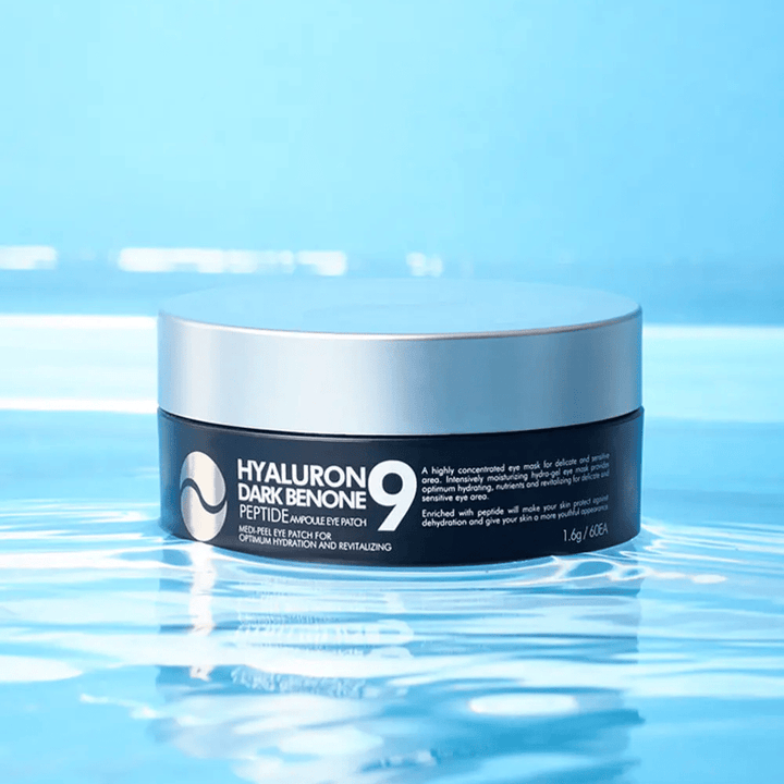 Hyaluron Dark Benone Peptide 9 Ampoule Eye Patch placeret på vandoverflade – fugtgivende koreanske øjenplastre med hyaluronsyre og peptider for friskere hud omkring øjnene.