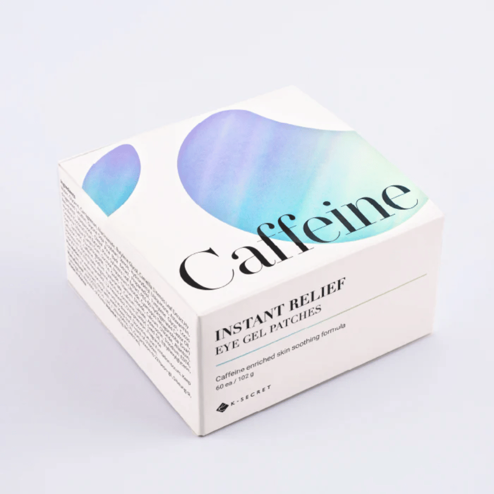 Pakning af K-Secret Instant Relief Eye Gel Patches med koffein i hvidt design med blå og grønne toner.