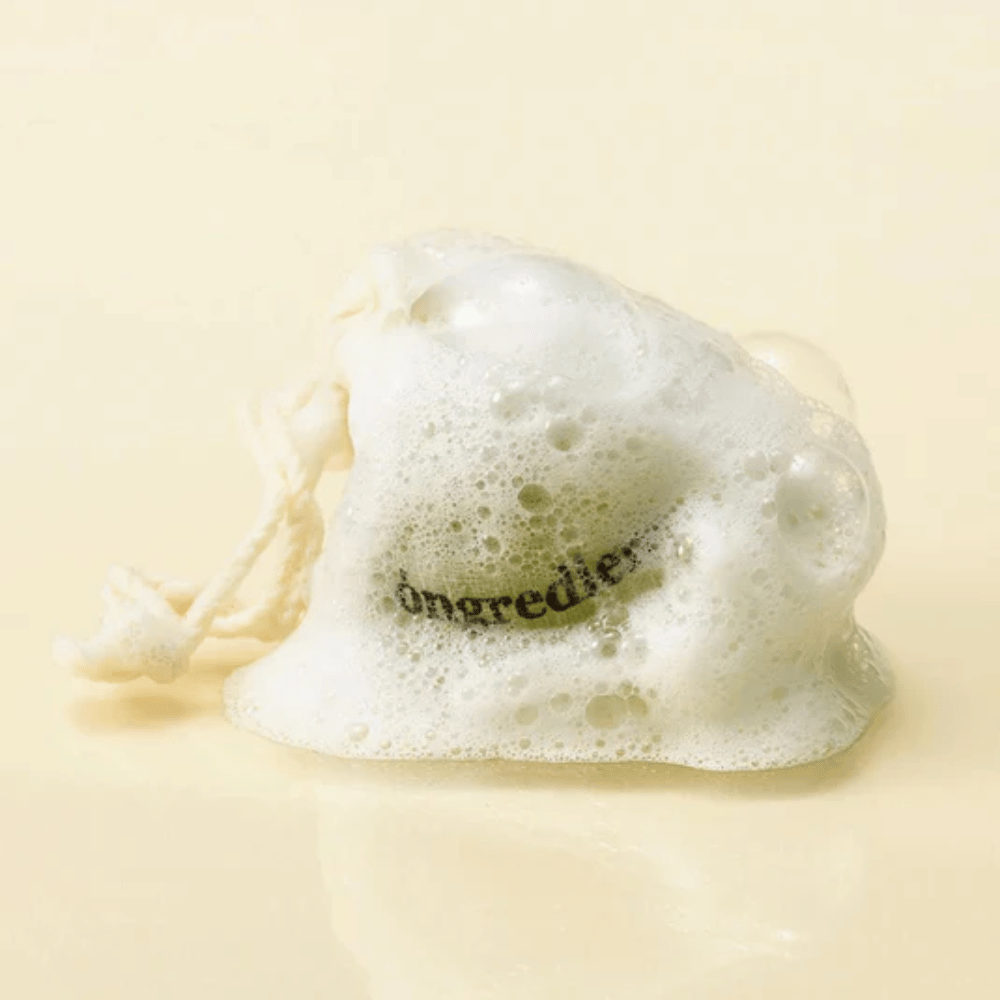 Óngredients Jeju Green Tea Cleansing Ball i netpose dækket af blødt skum – naturlig koreansk ansigtssæbe.