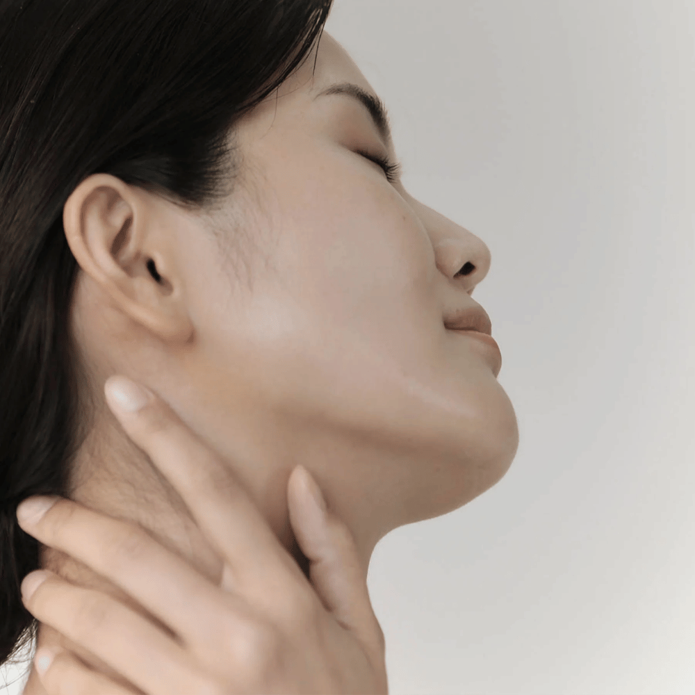 Kvinde viser sin rolige, fugtede hud efter brug af Celimax Ji Woo Gae Cica BHA Blemish Toner Pad.