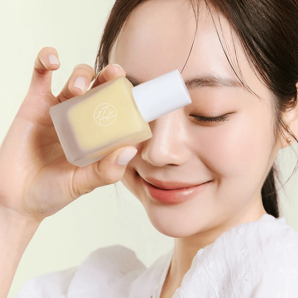 En kvinde holder en flaske KAINE Vita Drop Serum 30ml.