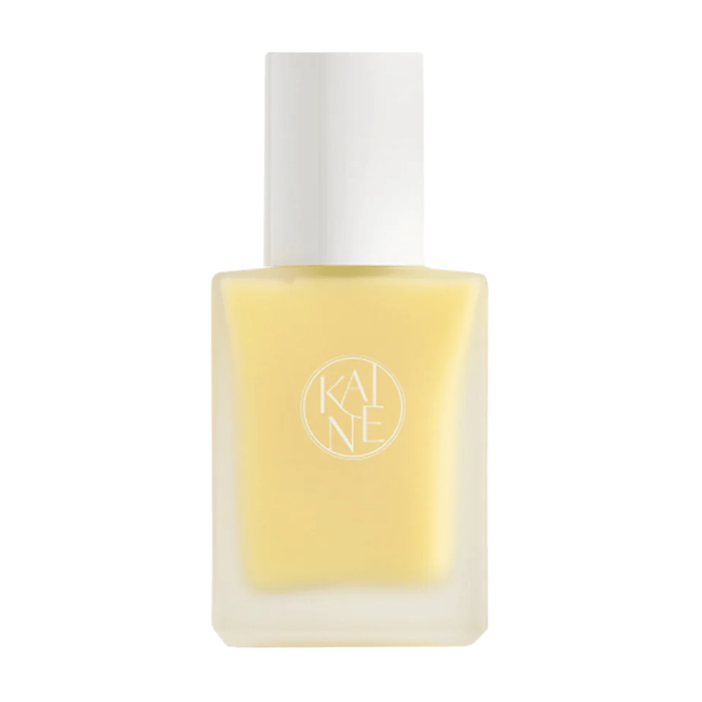 En gul Vita Drop Serum 30ml flaske på hvid baggrund med KAINE hudplejeprodukter.