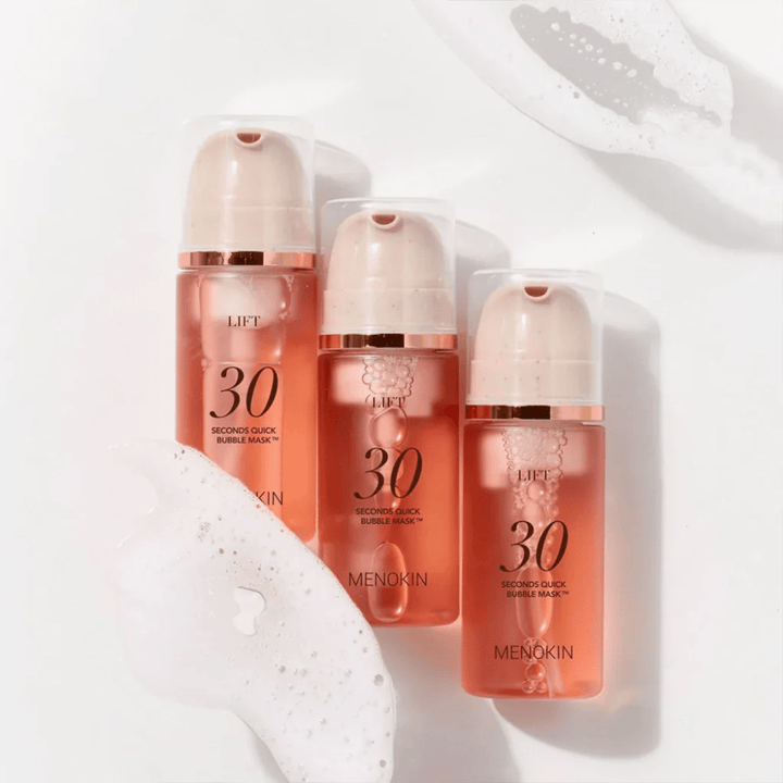 Æstetisk produktbillede med tre flasker af MENOKIN LIFT 30 Seconds Quick Bubble Mask omgivet af blødt skum, som fremhæver den boblende og rensende effekt.