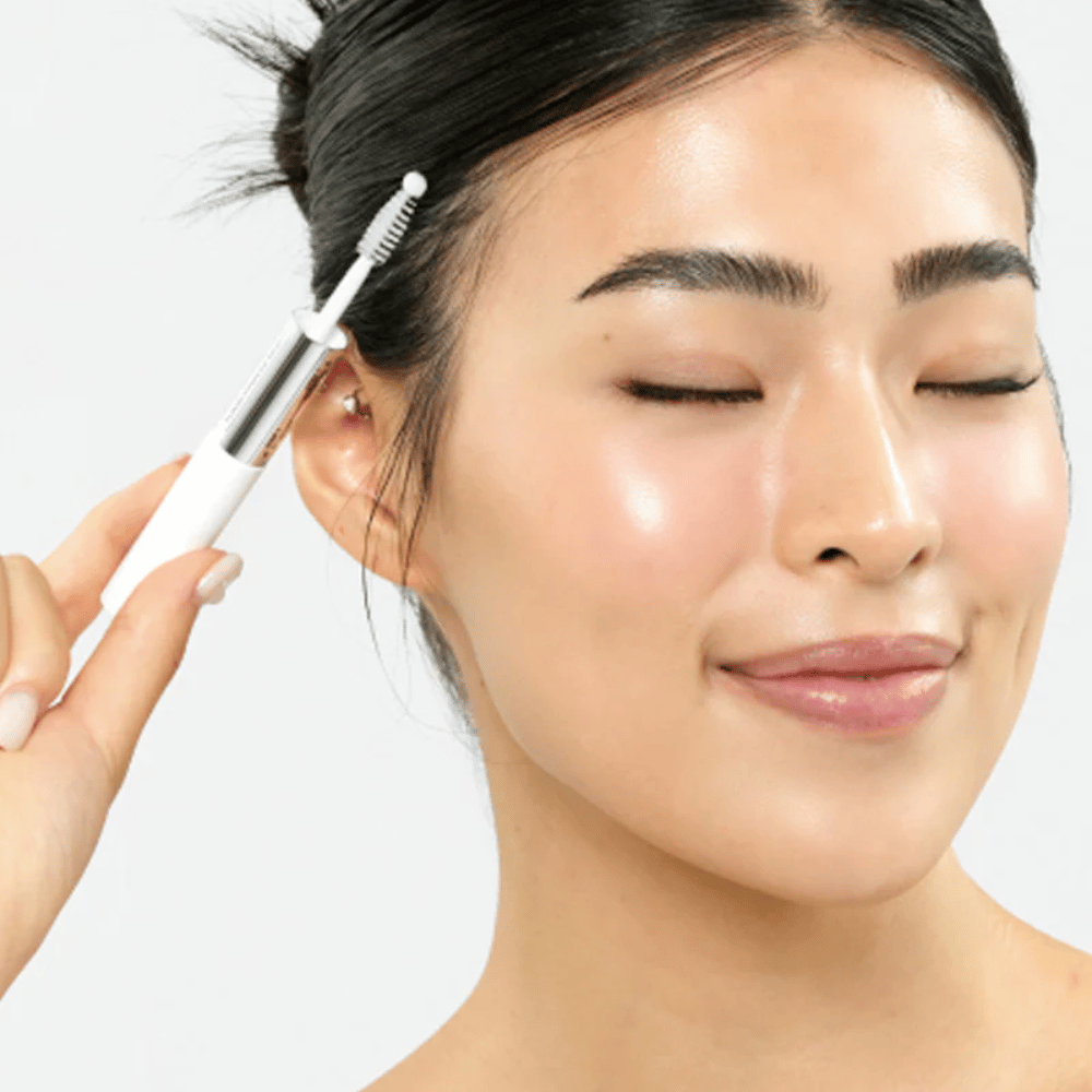 Kvinde påfører Seapuri Lashrum Eyelash Enhancing Serum på øjenvipper. Fremmer naturlig vækst og glans.