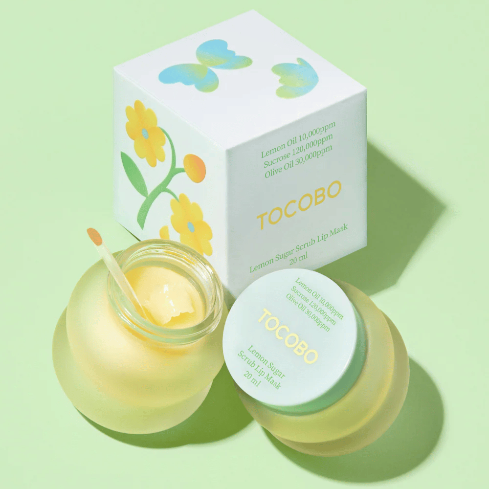 Tocobo Lemon Sugar Scrub Lip Mask sammen med sin emballage med blomsterdesign på en lysegrøn baggrund.