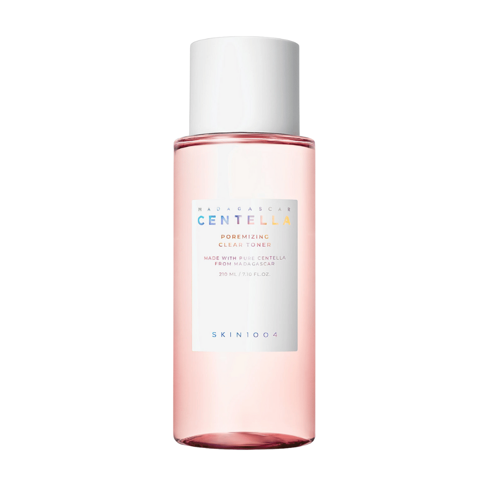 En flaske med Madagascar Centella Poremizing Clear Toner, som er transparent med en lyserød tone. Produktet har en hvid kork og etiket med teksten "Poremizing Clear Toner" og "Made with Pure Centella from Madagascar." Flasken rummer 210 ml og giver en følelse af friskhed og hudpleje.