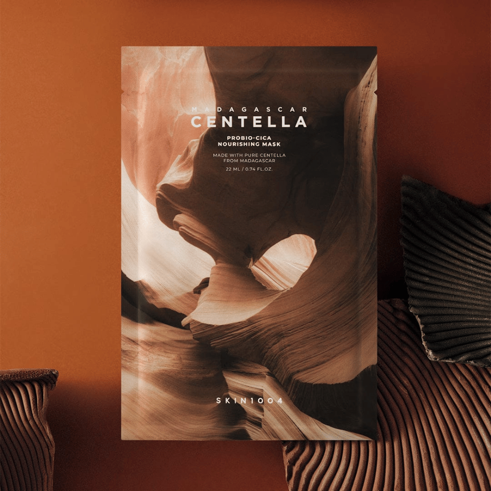 Sheet mask-emballage fra SKIN1004 mod varm brun baggrund med naturinspireret design.