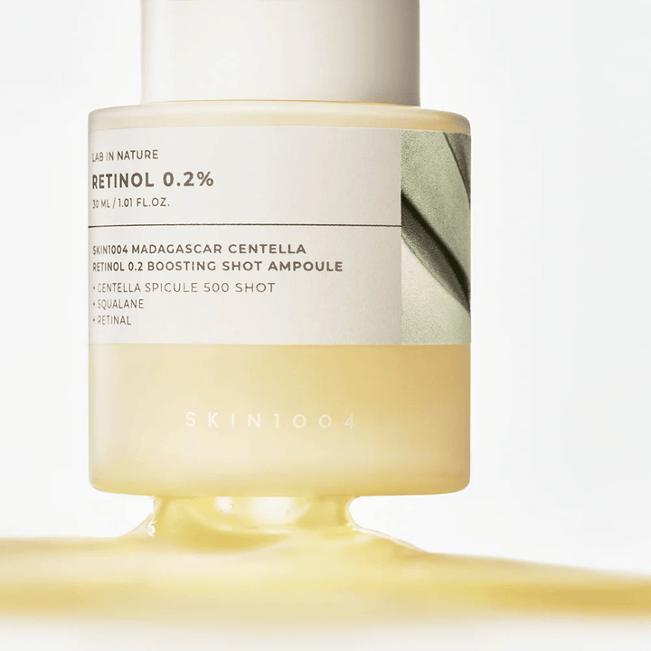 Nærbillede af SKIN1004 Madagascar Centella Retinol 0.2 Boosting Shot Ampoule som viser den letgule, silkebløde konsistens af retinolserummet til natlig hudfornyelse.