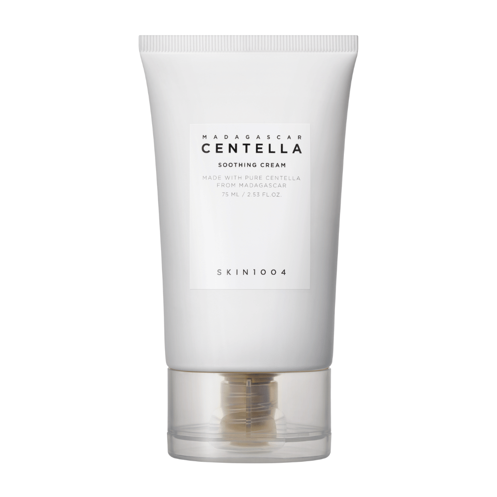 Et hvidt rør af Madagascar Centella Soothing Cream fra SKIN1004 med gennemsigtig kork. Teksten på røret beskriver produktet som beroligende og fremstillet med ren Centella fra Madagaskar. Røret indeholder 75 ml / 2.53 fl. oz.