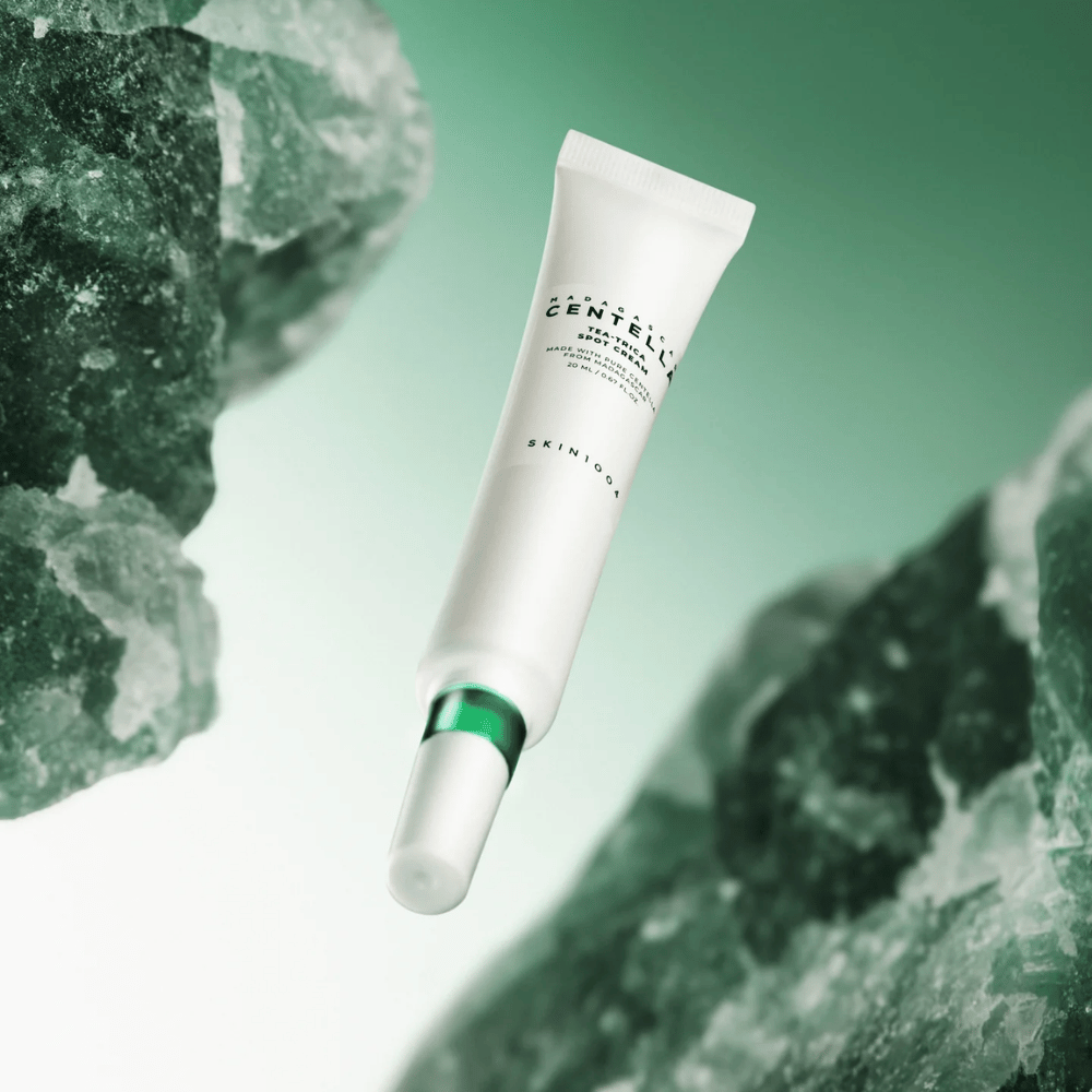 SKIN1004 Madagascar Centella Tea-Trica Spot Cream 20 ml mod akne og bumser, produktbillede med grøn baggrund og krystalstruktur – beroligende spot treatment med centella asiatica og tea tree.