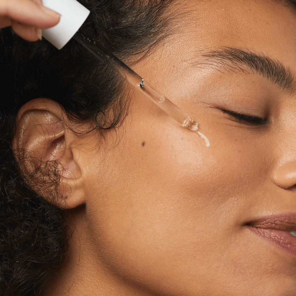 Kvinde påfører Skin1004 Madagascar Centella Hyalu-Cica First Ampoule på kinden med en pipette.