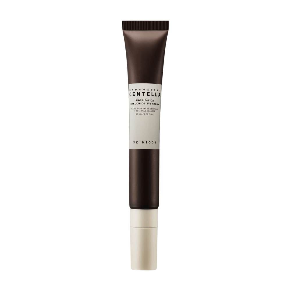 En tube af "Madagascar Centella Probio-Cica Bakuchiol Eye Cream" fra SKIN1004. Produktet er designet til øjenområdet og indeholder ingredienser såsom centella fra Madagaskar og bakuchiol, kendt for deres hudplejende og fugtgivende egenskaber. Tuben er stilren med en mørkebrun farve, der går over i hvid.