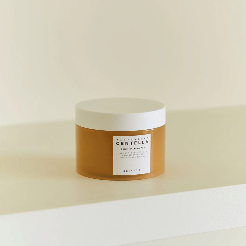 SKIN1004 Madagascar Centella Quick Calming Pad placeret på hvid hylde – ravfarvet bøtte med hvidt låg og tydelig etiket foran.