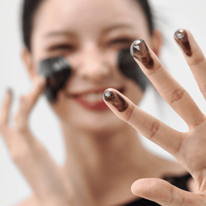 Model anvender Hvordan Midnight Soothing Cleansing Balm på huden. Cremet cleansing balm, der renser i dybden og efterlader huden blød og balanceret.