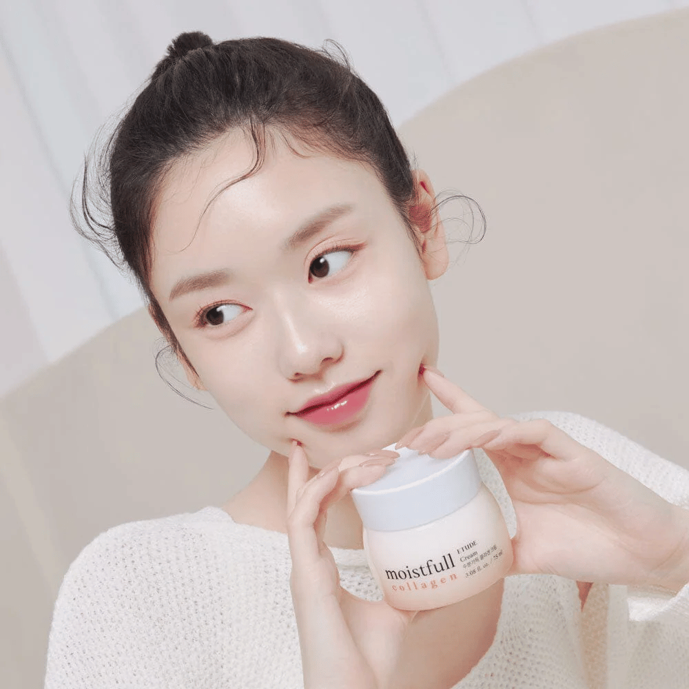 Kvinde holder en dåse "Moistfull Collagen Cream", hvid trøje, smilende.