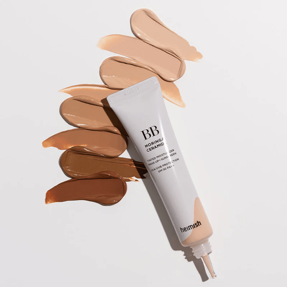 Heimish Moringa Ceramide BB Cream omgivet af flere nuanceprøver i forskellige hudtoner. Billedet viser produktets brede farveudvalg og den cremede konsistens, som giver naturlig dækning og en ensartet hudtone.