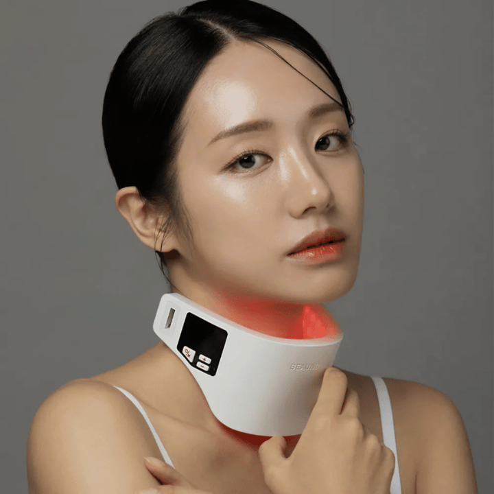 Model bruger Beaund Neckcera omkring halsen. Den røde LED-belysning illustrerer den aktive behandling, mens enheden sidder behageligt mod huden.