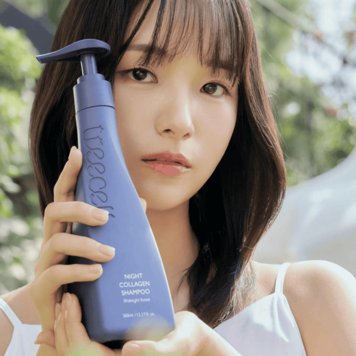 Kvinde holder Treecell Night Collagen Shampoo Midnight Forest op i et naturligt miljø. Billedet formidler sundt hår, glans og premiumfølelse med fokus på hår- og hovedbundspleje.