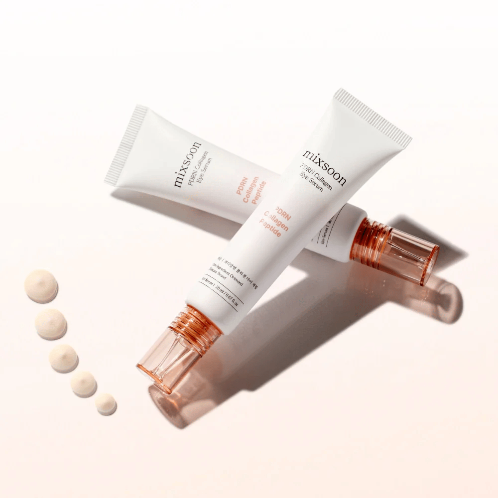 To tuber af Mixsoon PDRN Collagen Eye Serum ligger krydsede med små dråber af serumet. En let øjenbehandling, der fugter og udglatter linjer.