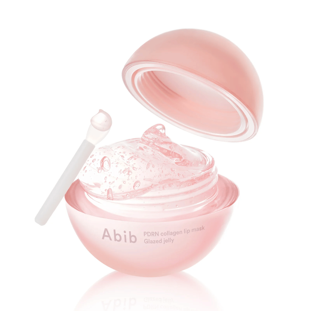 Rosa rund dåse med Abib PDRN Collagen Lip Mask Glazed Jelly, åben med låg vippet bagud. Gennemsigtig gel med luftbobler ses i dåsen sammen med en lille spatel.