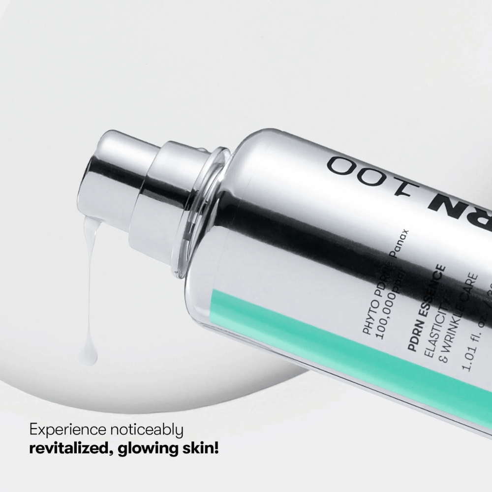 Nærbillede af en sølvfarvet pumpeflaske med VT PDRN Essence 100. En hvid essens løber ud fra mundstykket, og teksten på billedet lyder: "Experience noticeably revitalized, glowing skin!"