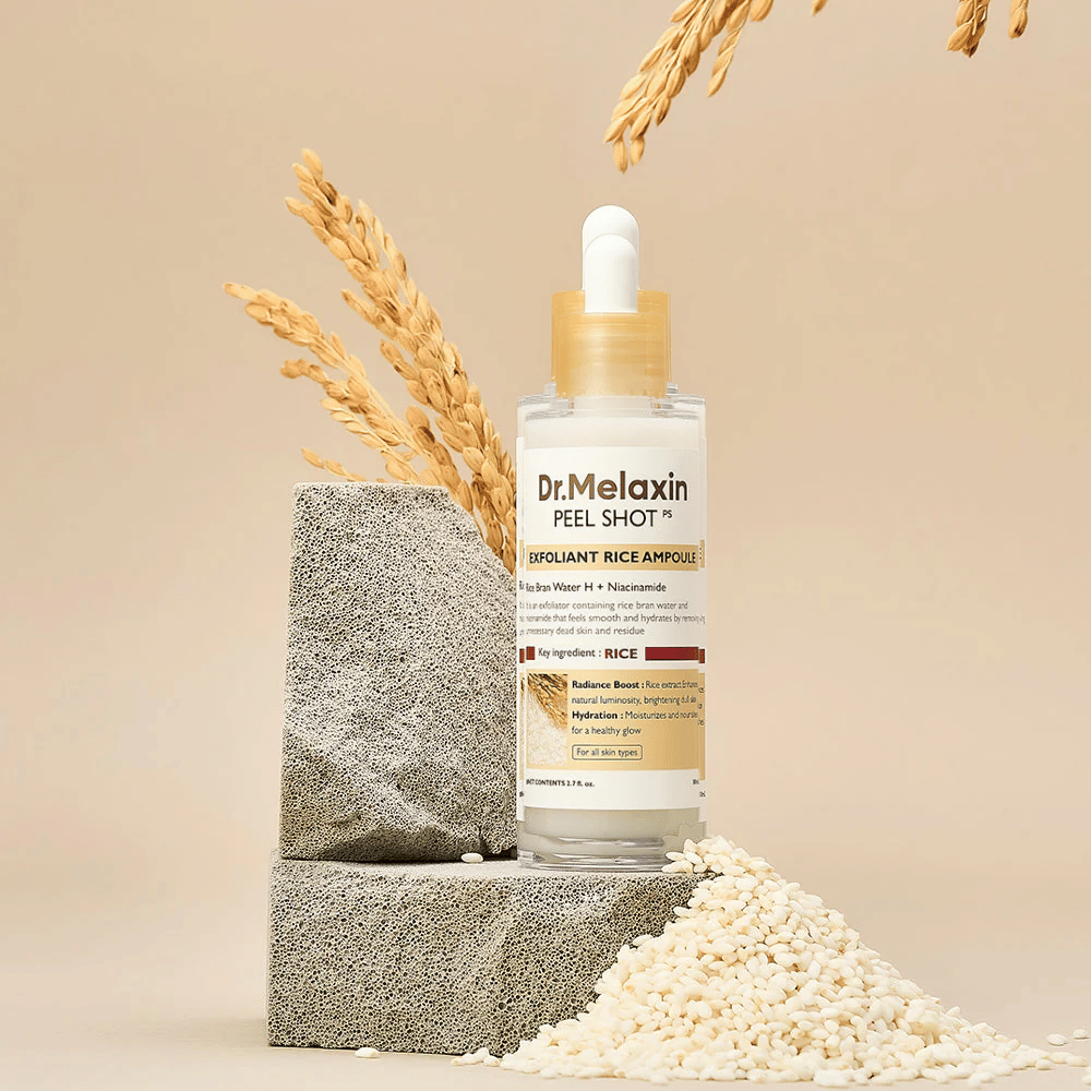 Dr.Melaxin Peel Shot Exfoliant Rice Ampoule opstillet med ris og stenblok, koreansk eksfolierende ampul med risekstrakt og niacinamid for klarere og blødere hud.