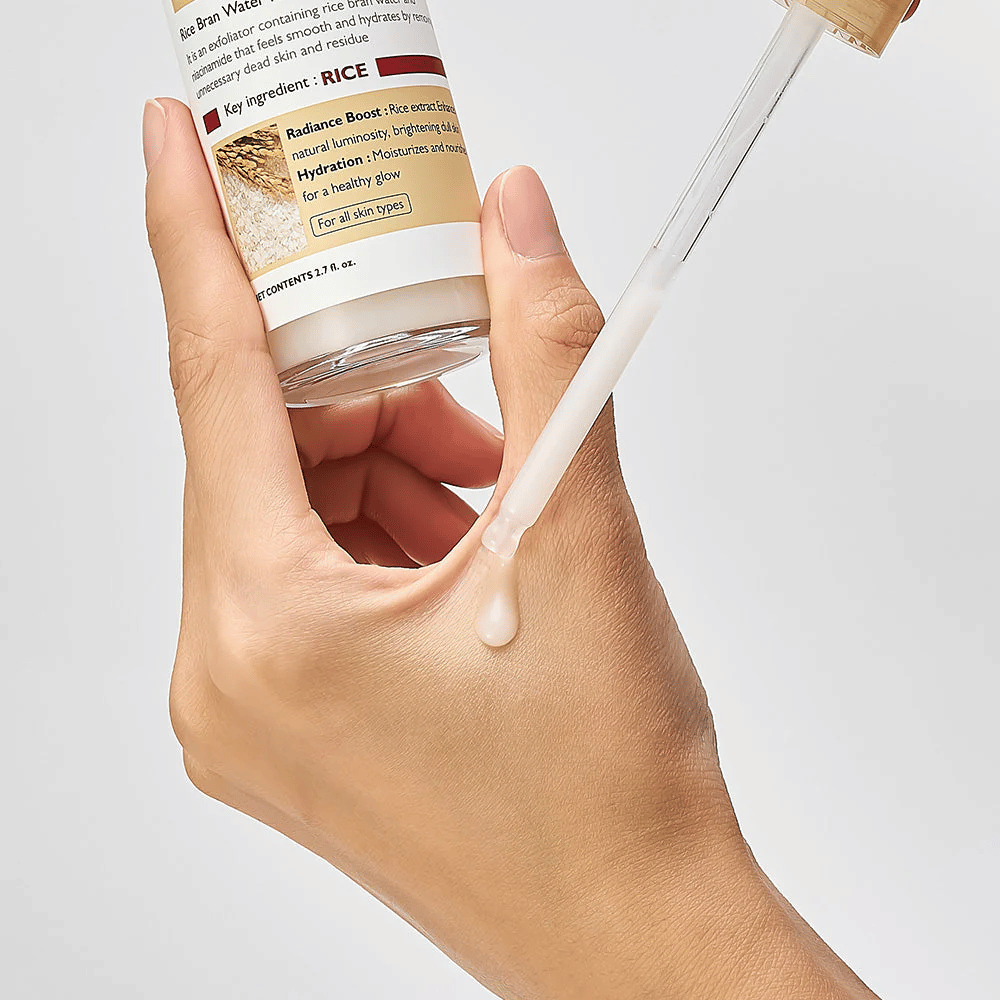 Nærbillede af Dr.Melaxin Peel Shot Rice Ampoule påført med pipette på hånd, letflydende eksfolierende ampul der absorberes hurtigt og giver fugtet, glat hud.