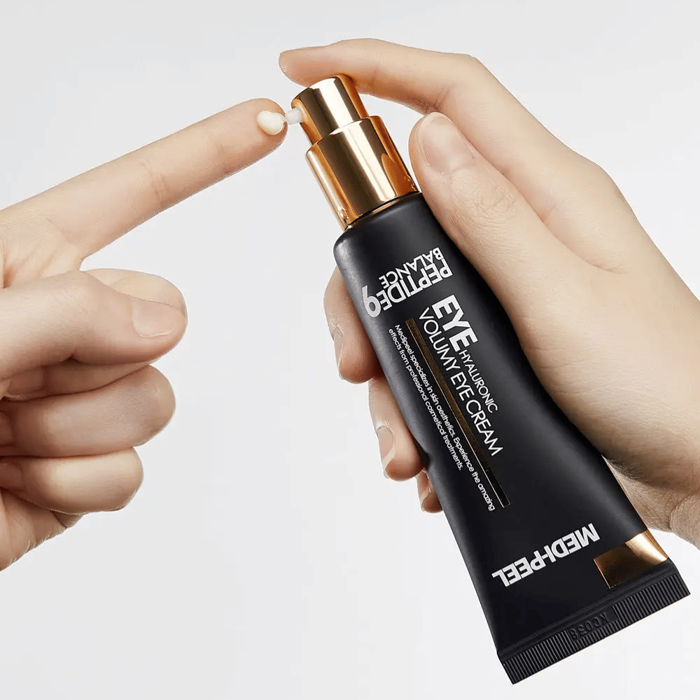 Anvendelse af MEDI-PEEL Peptide 9 Hyaluronic Volumy Eye Cream på fingerspids – fugtgivende øjencreme med peptidkompleks, der hjælper med at reducere fine linjer og give fyldigere hud.