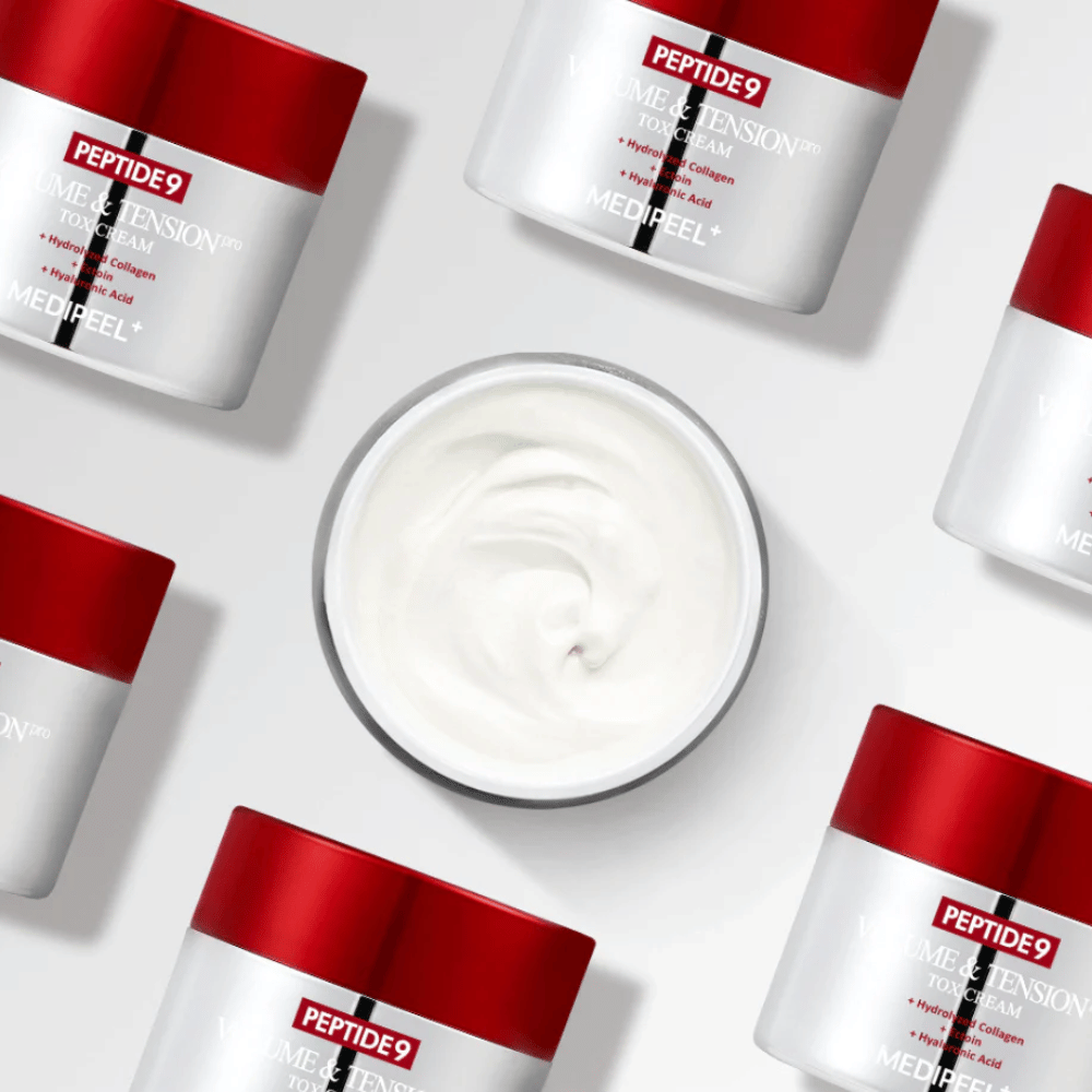 Flere krukker af MEDI-PEEL Peptide 9 Volume & Tension Tox Cream arrangeret mod hvid baggrund. Produktet fugter intensivt og giver huden volumen og glans.