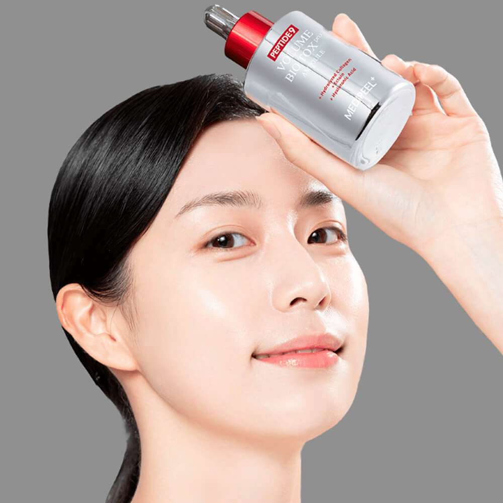 Person holder MEDI-PEEL Peptide 9 Volume Bio Tox Pro Ampoule mod panden. Huden ser fugtet og strålende ud – serumet styrker elasticitet og fasthed.