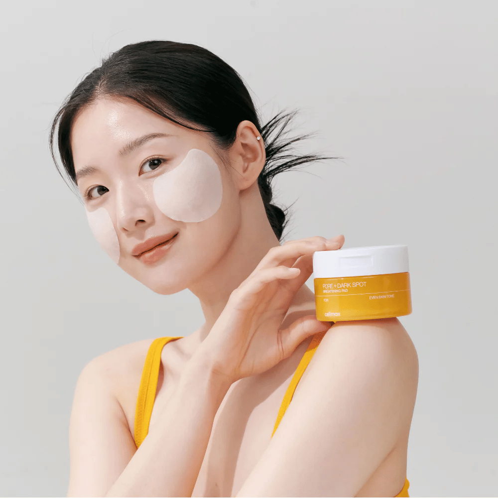 Kvinde anvender Celimax Pore + Dark Spot Brightening Pad – koreanske pads der jævner hudtonen og reducerer porer og pigmentpletter.