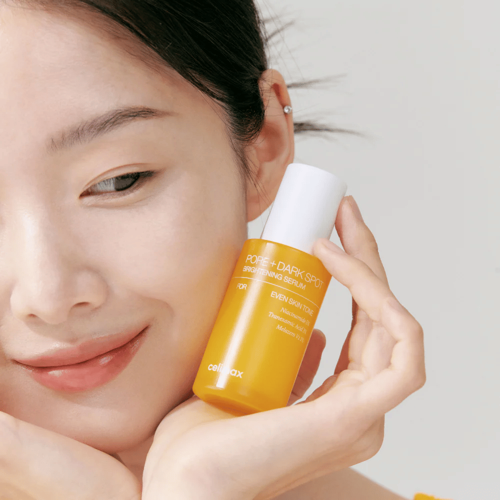 Model holder Celimax Pore + Dark Spot Brightening Serum tæt på ansigtet, viser strålende hud.