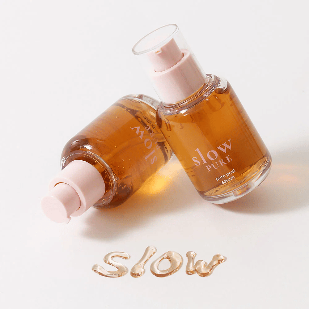 To flasker Slow Pure Pore Peel Serum med pumpe, tekst skrevet i serum på overfladen: "Slow".