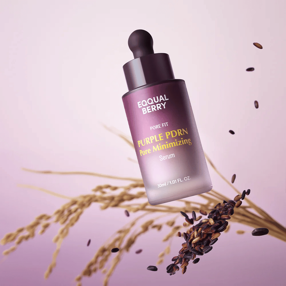 Flaske med Equal Berry Purple PDRN Pore Minimizing Serum svæver mod lilla baggrund, omgivet af sorte risgryn og risstrå.