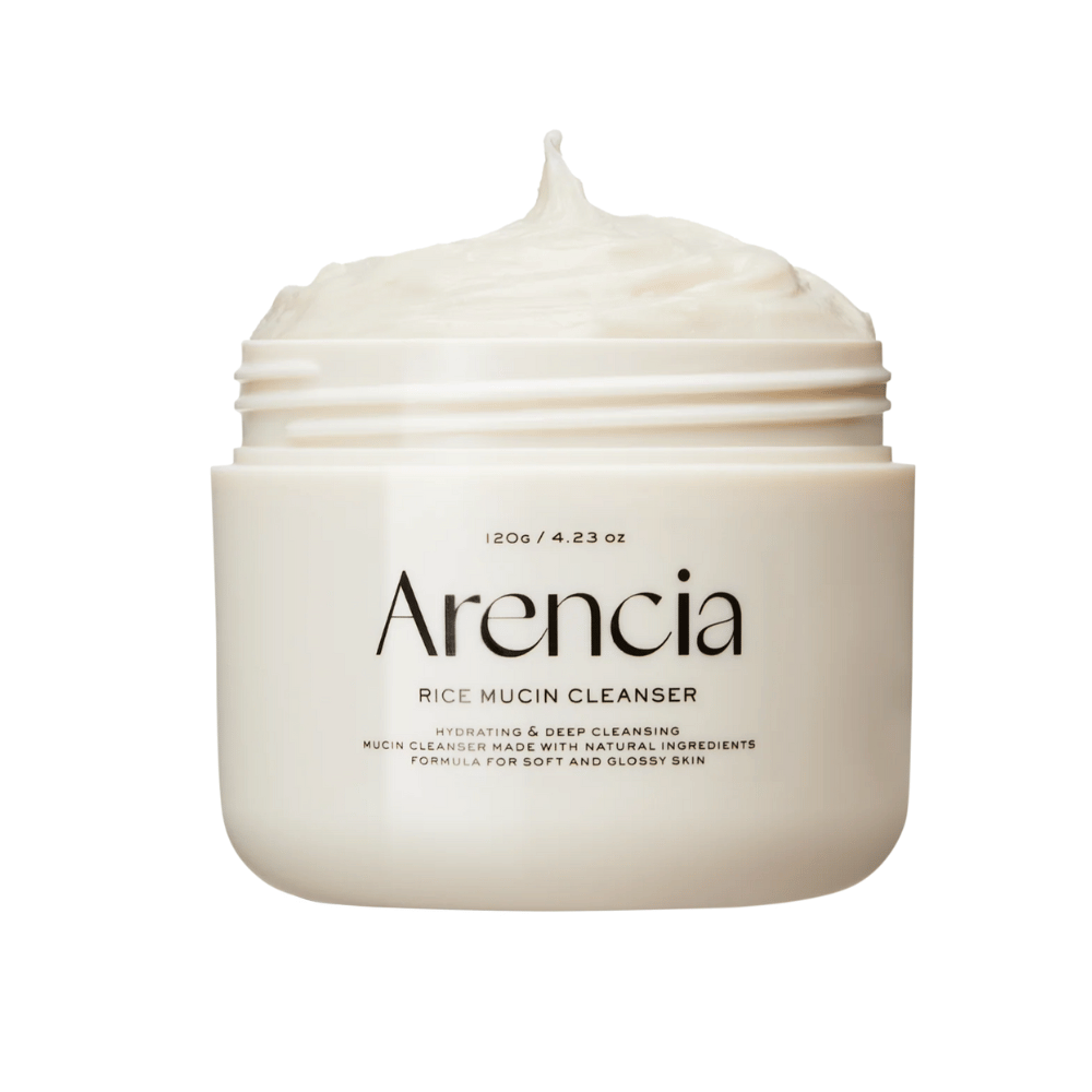 Produktbillede på Arencia Rice Mucin Cleanser i en hvid krukke med cremet, pisket tekstur, der stikker op af åbningen. Tekst på emballagen fremhæver fugtgivende og dybderensende egenskaber.