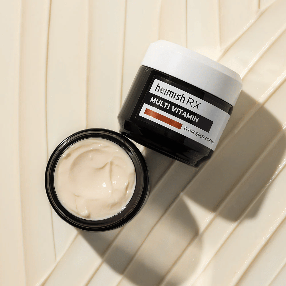 heimish RX Multi Vitamin Dark Spot Cream – en næringsrig ansigtscreme til at reducere mørke pletter og give huden en jævnere tone. Cremens bløde tekstur vises i en åben krukke med elegant emballage.