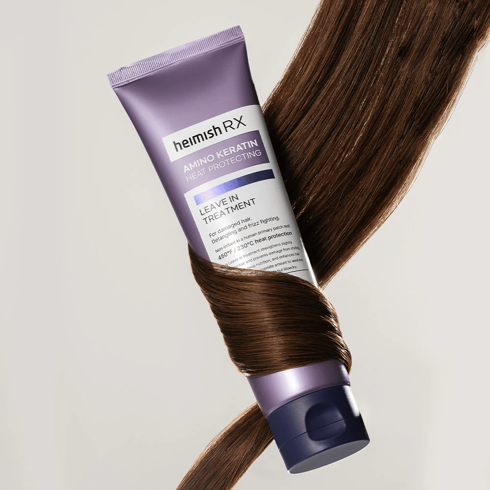 Heimish RX Amino Keratin Leave-In Treatment – næringsrig varmebeskyttende hårbehandling omgivet af skinnende hår, symboliserer styrkende og fugtgivende effekt for skadet hår.