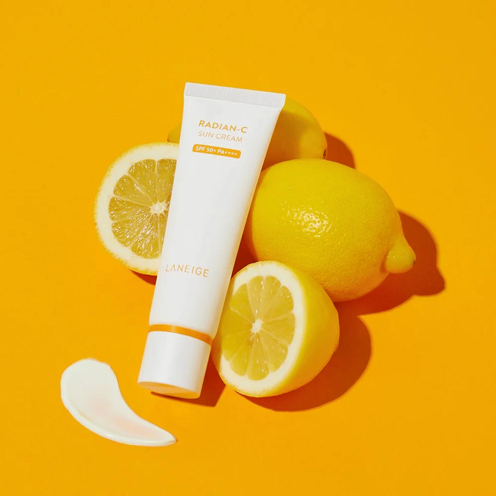 LANEIGE Radian-C Sun Cream SPF 50+ PA++++ med citroner og en klat solcreme på en farverig gul baggrund.