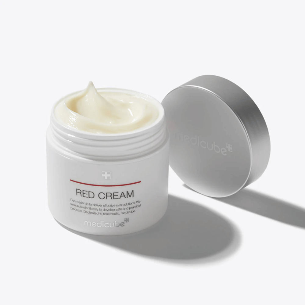 Åben krukke med {{0e9300bdc88a9e2bbdf71c1a0784b64d}} Red Cream 50ml – en lysegul ansigtscreme i hvid emballage med sølvfarvet låg, udviklet til akne-udsat hud.