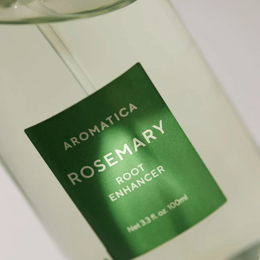 Detaljebillede af etiketten på AROMATICA Rosemary Root Enhancer. Den grønne etiket og den transparente flaske fremhæver produktets rene og minimalistiske udseende.