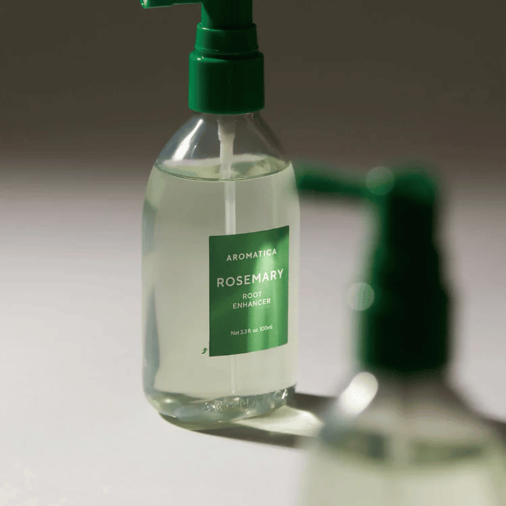 Nærbillede af AROMATICA Rosemary Root Enhancer med grøn applikatordyse. Billedet fokuserer på flaskens design og den præcise påføring direkte mod hovedbunden.