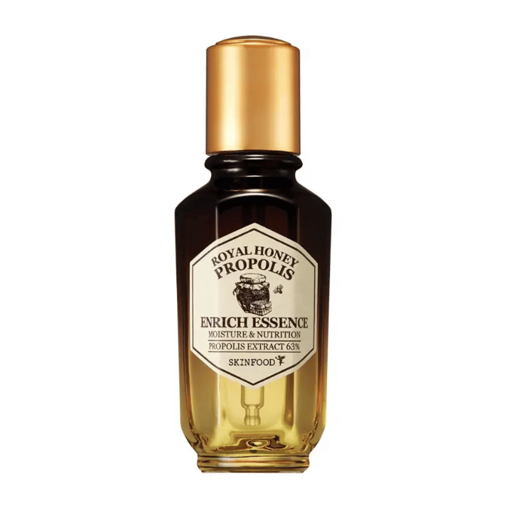 Billede af en glasflaske med mørk væske og guldfarvet låg. På flaskens etiket står der "Royal Honey Propolis Enrich Essence" efterfulgt af "Moisture & Nutrition" og "Propolis Extract 63%". Mærket "Skinfood" ses også nederst på etiketten.