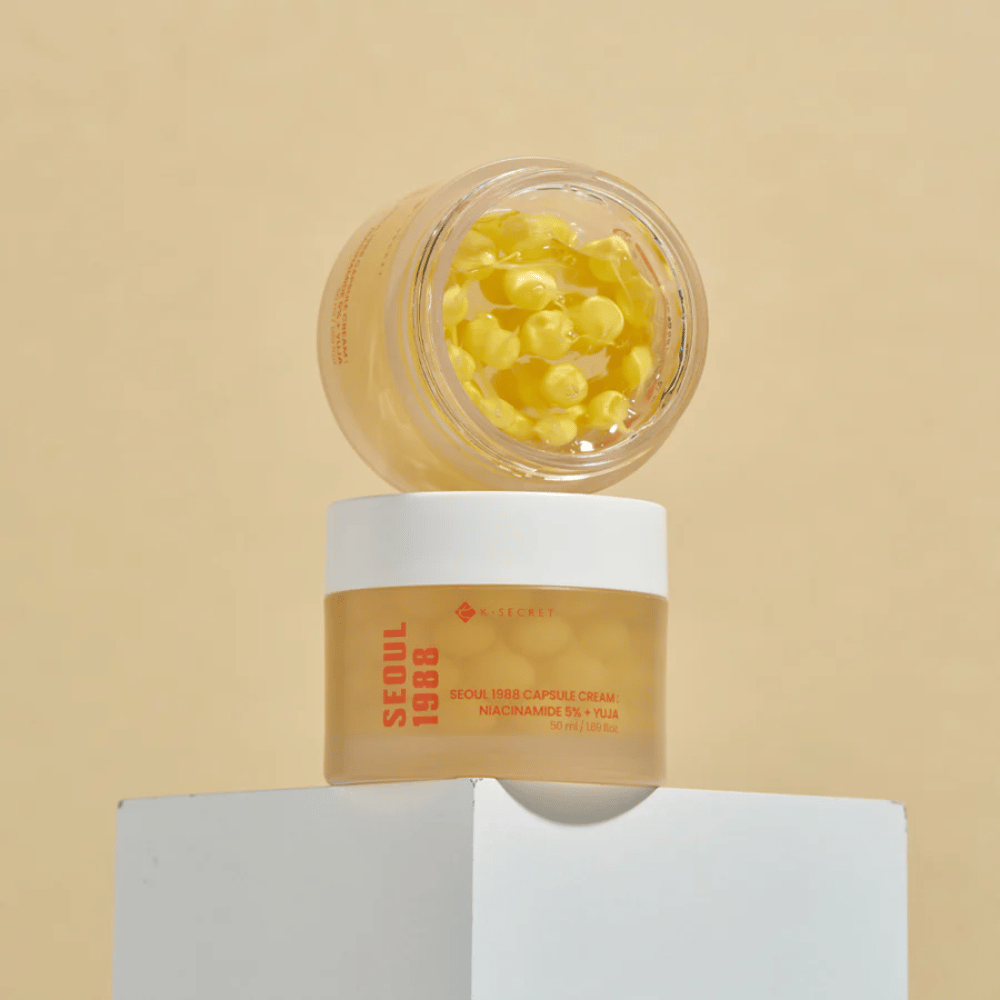 Stilren opstilling: To krukker med Seoul 1988 Capsule Cream, en åben og en lukket, placeret mod beige baggrund.