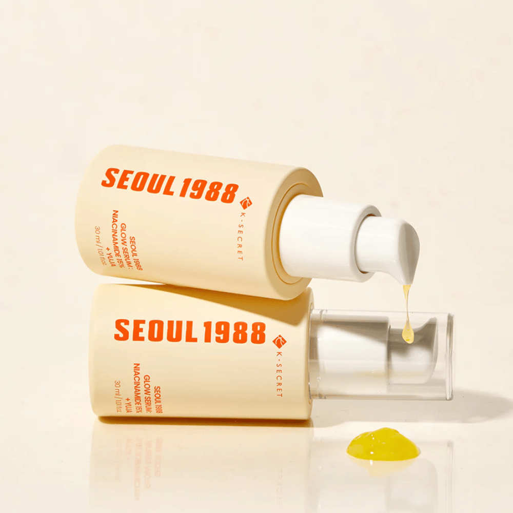 To flasker Seoul 1988 Glow Serum liggende og stående, med gul serum dryppende fra pumpen.