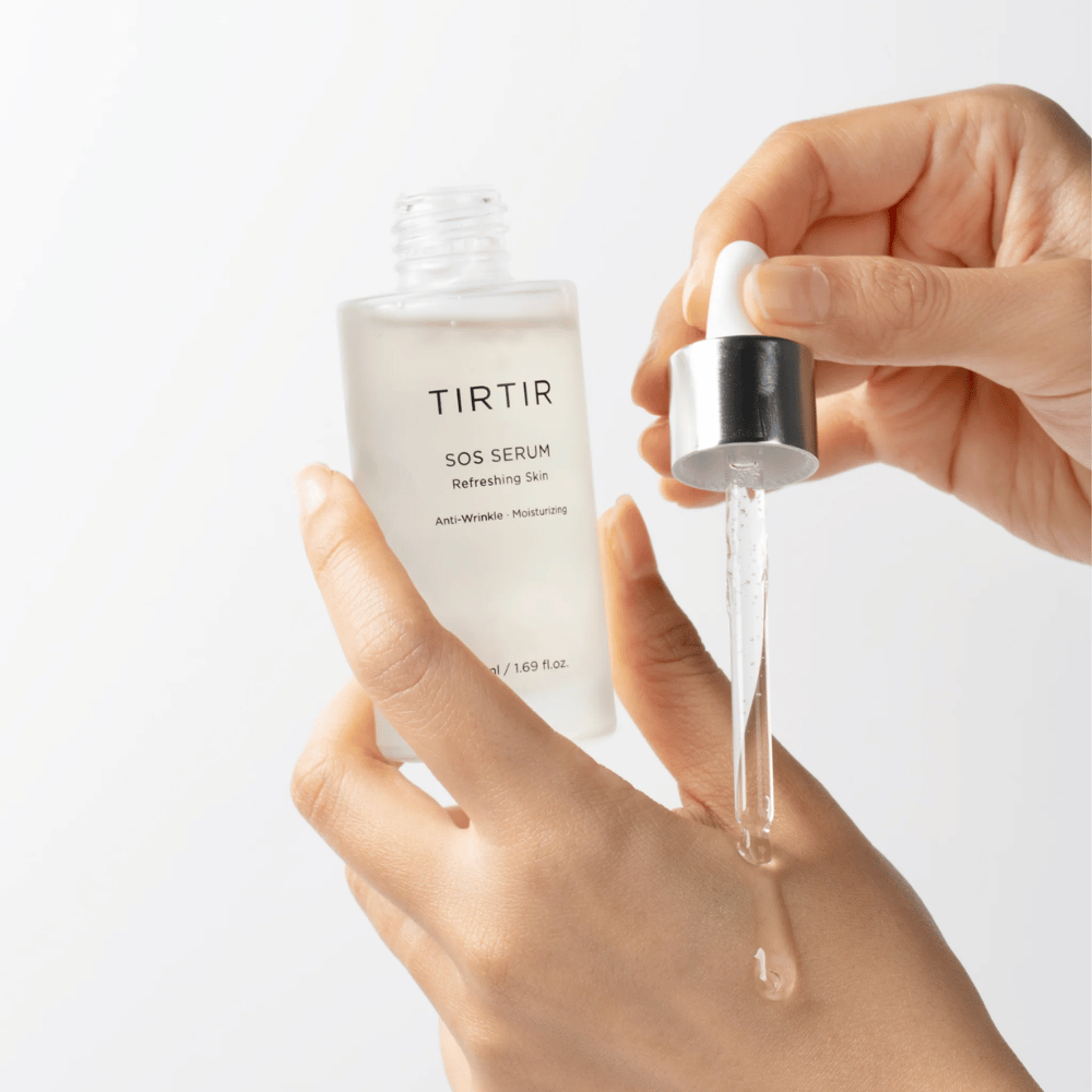 Hænder, der drypper TIRTIR SOS Serum fra en pipette, beregnet til hudpleje.