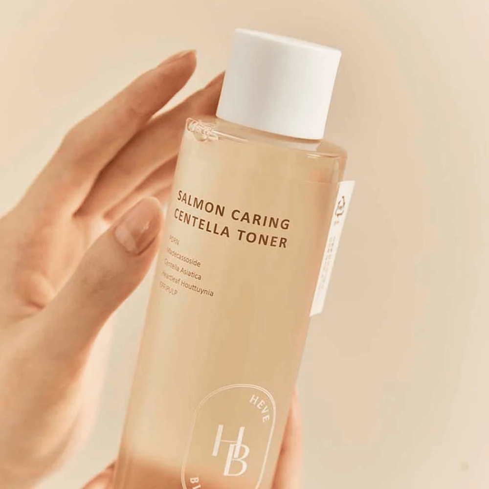 Nærbillede af Salmon Caring Centella Toner i hånden – beroligende toner med PDRN og planteekstrakt som hjælper med at styrke huden og mindske følelsen af irritation.