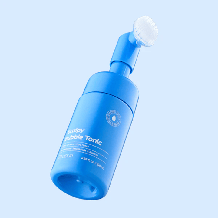 Stilrent produktbillede af Seapuri Scalpy Bubble Tonic mod lyseblå baggrund, som fremhæver det moderne design og det unikke børstehoved til hovedbundspleje.