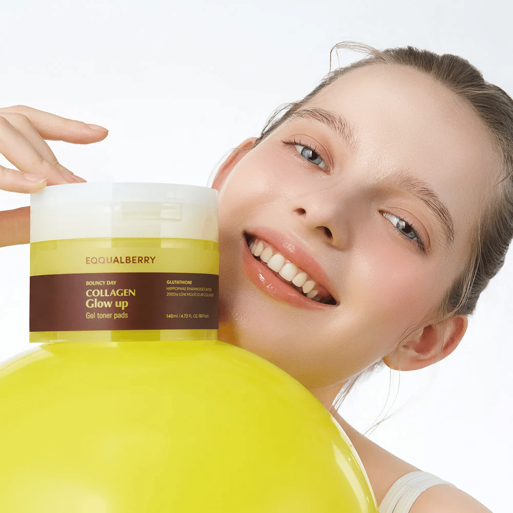 Smilende model, der holder Bouncy Day Collagen Glow up Gel Toner Pads, som hjælper med at give en ungdommelig glød og fasthed med lavmolekylært kollagen og glutathion.