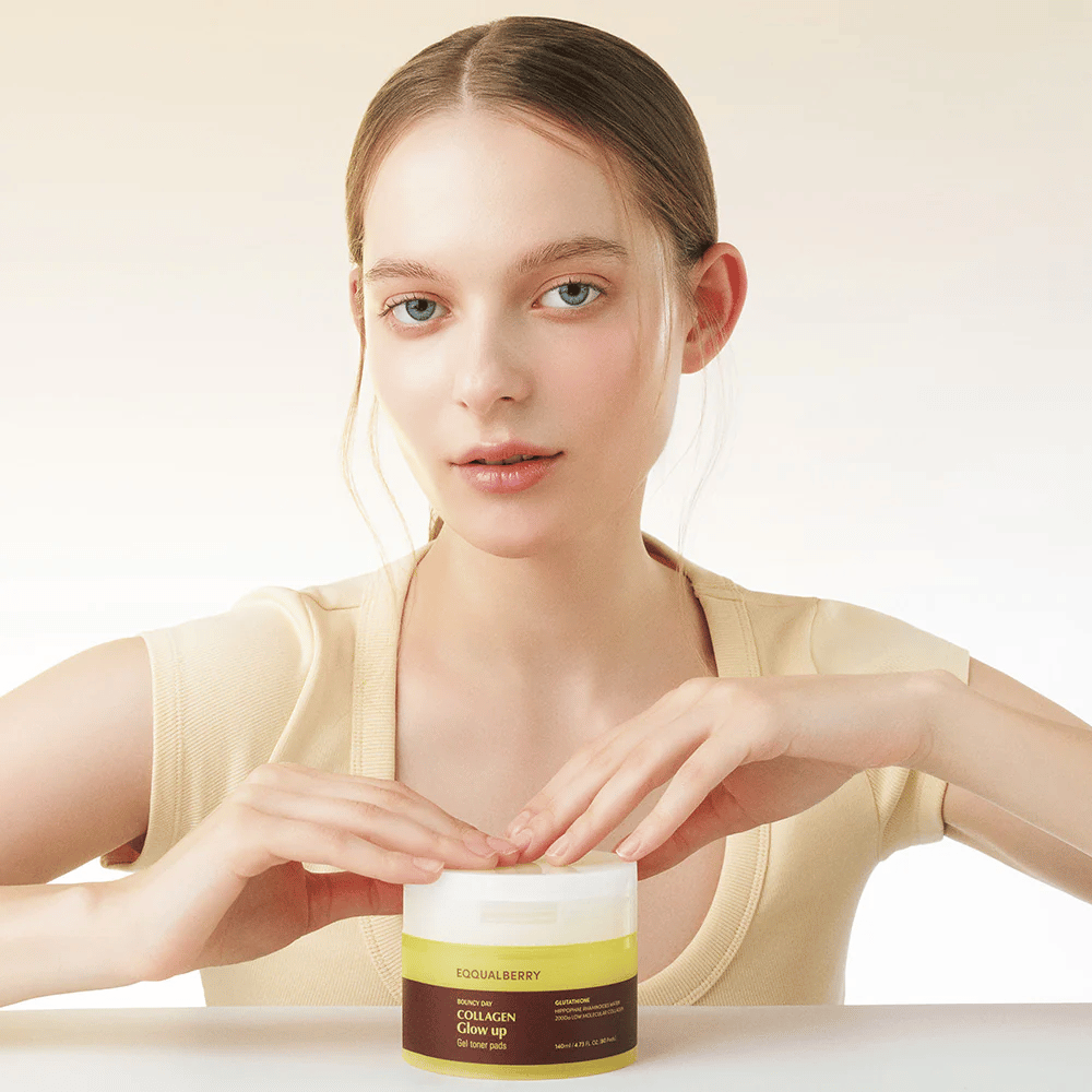 Model, der holder Bouncy Day Collagen Glow up Gel Toner Pads, som fugter og giver en smuk glød med lavmolekylært kollagen og glutathion.